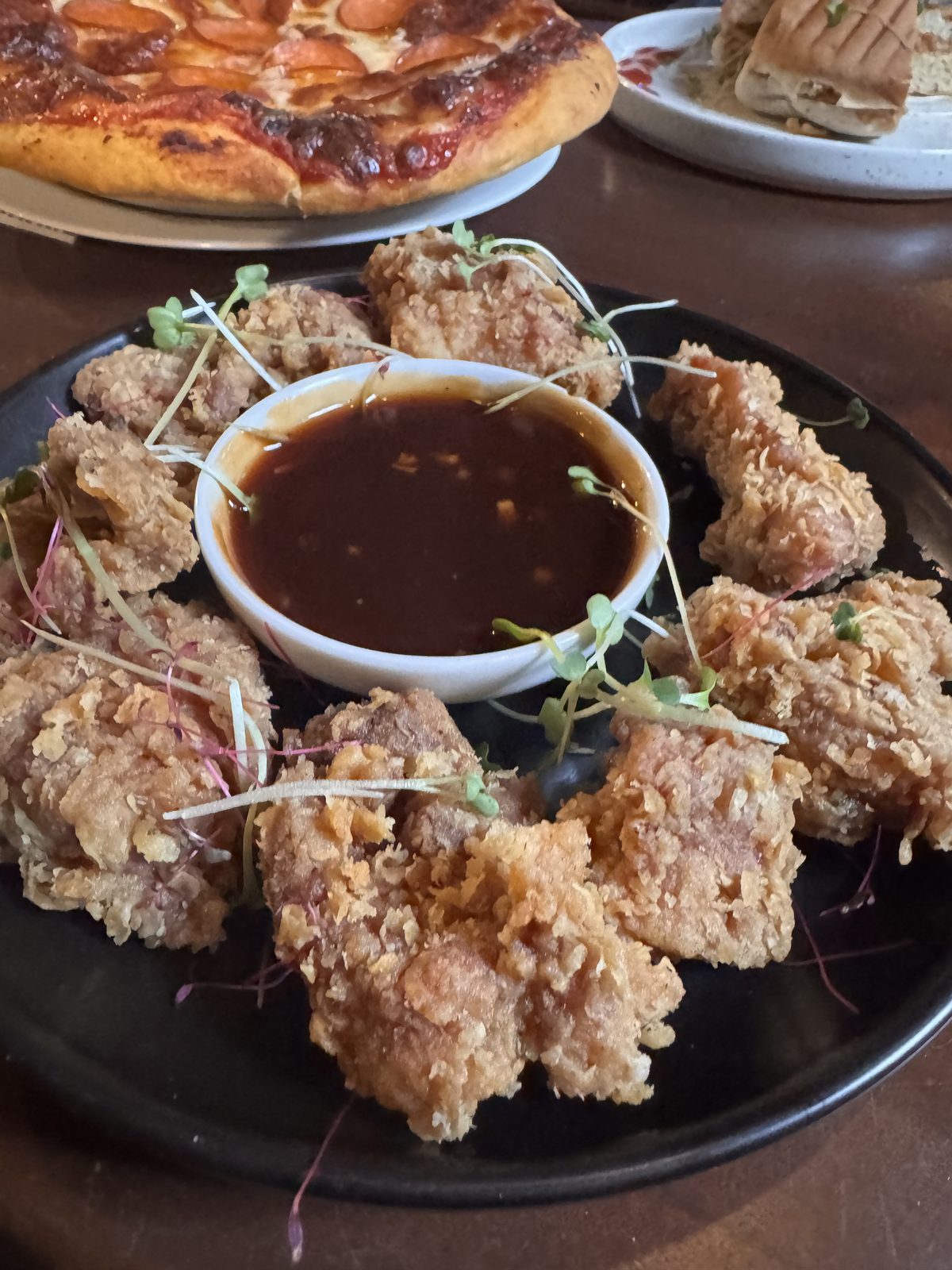 Crispy fried bites around a dark dipping sauce