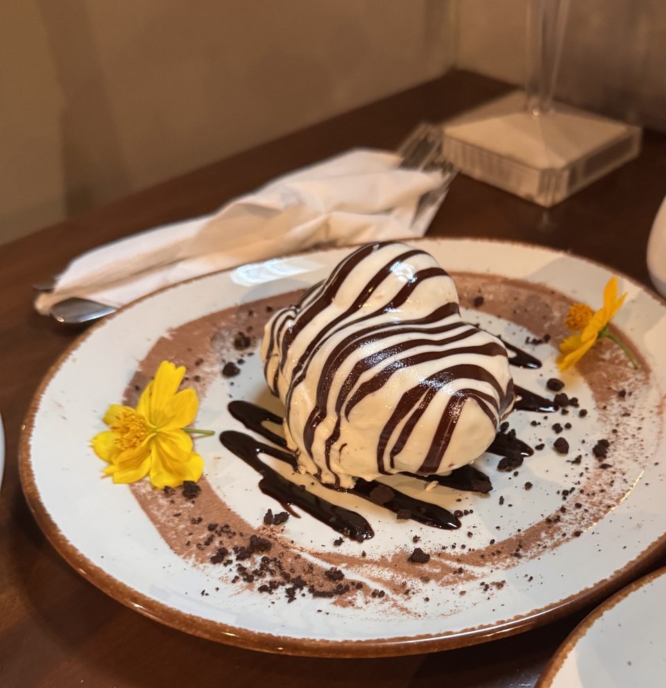 A heart-shaped dessert with chocolate stripes and yellow flowers