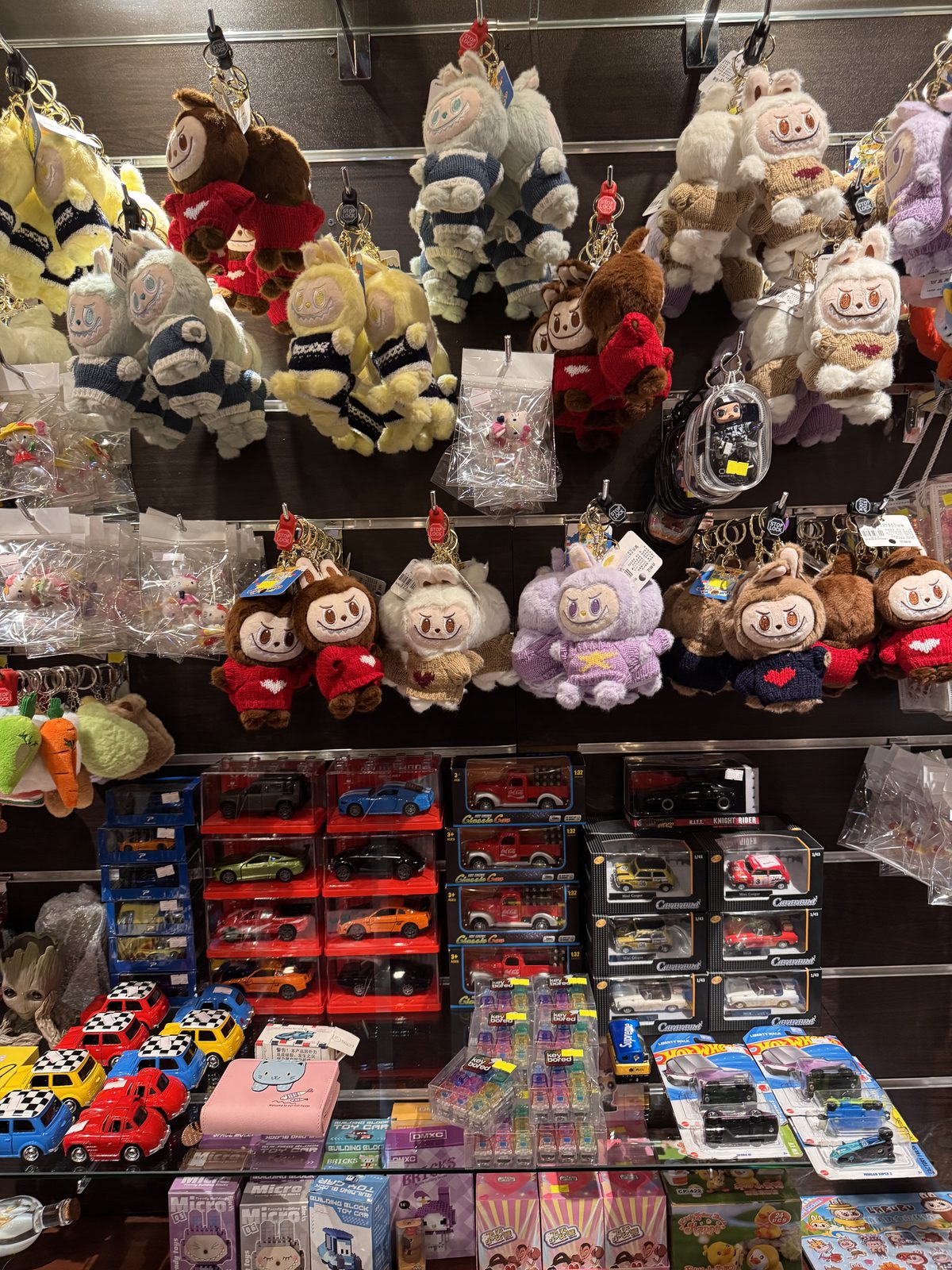 Keychains above a wall of toy cars