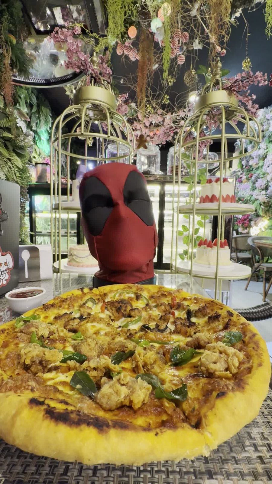 A pizza on the table, with the mask behind it
